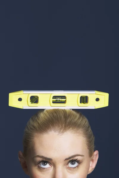 女性の頭の上に水準器を分散 — ストック写真