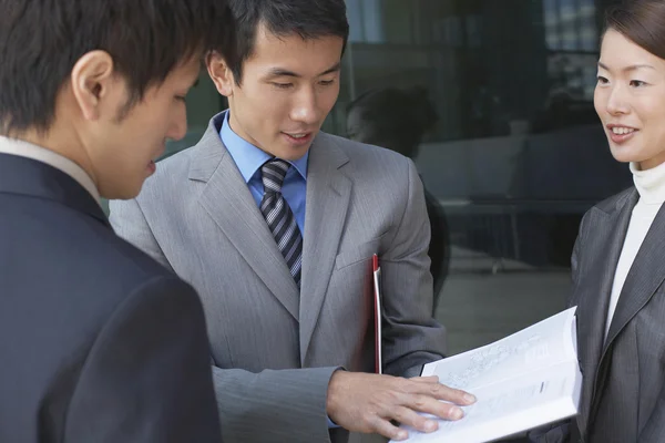 Businesspeople looking over documents — Stock Photo, Image