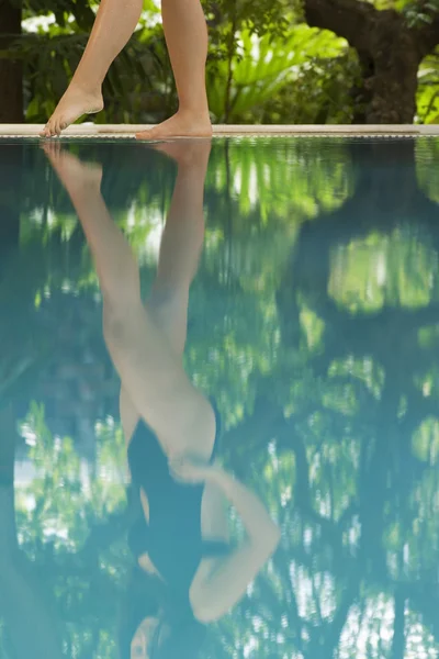 Mulher de pé na borda da piscina — Fotografia de Stock