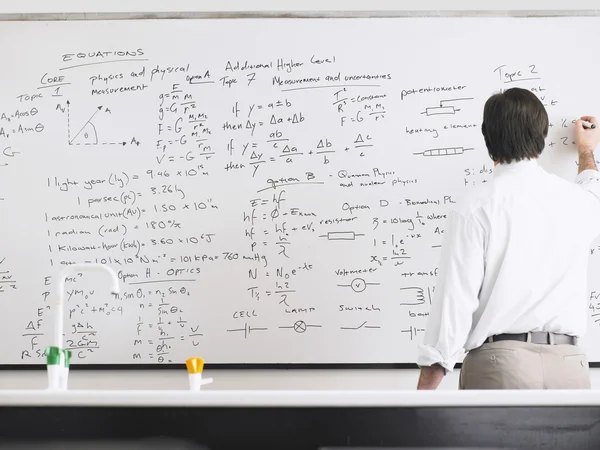Teacher writing on whiteboard — Stock Photo, Image