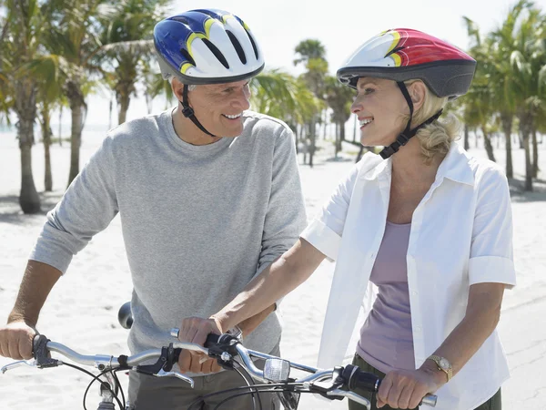 Couple with bicycles on tropical beach — Stock Photo, Image