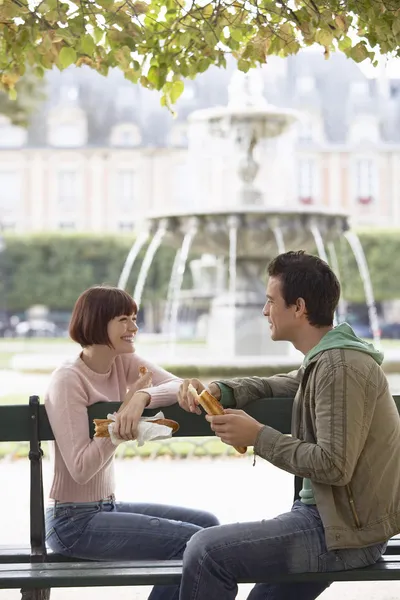 Felice giovane coppia mangiare baguette — Foto Stock