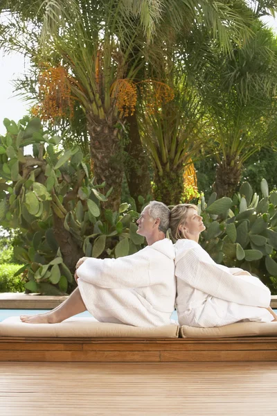 Couple sitting by pool — Stock Photo, Image