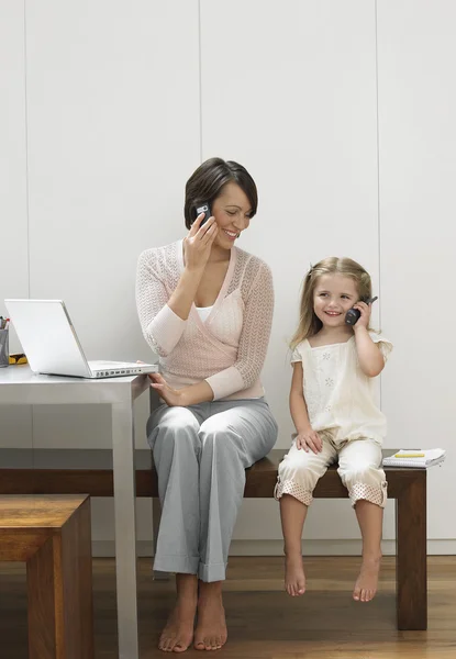 Madre e hija usando teléfonos celulares — Foto de Stock