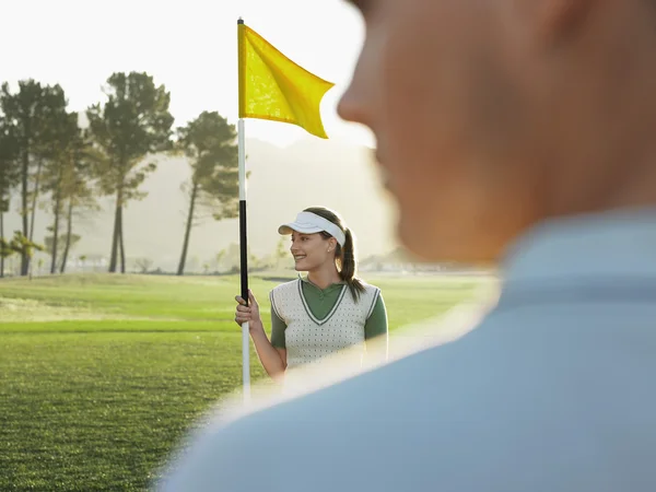 Golfista držení vlajky — Stock fotografie