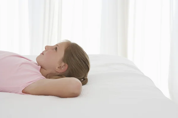 Mädchen entspannt sich auf dem Bett — Stockfoto