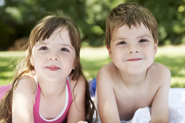 Niño y niña acostados en la hierba — Foto de Stock