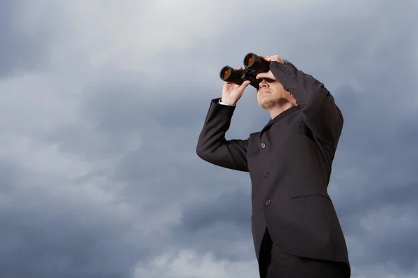 Geschäftsmann blickt durch Fernglas — Stockfoto