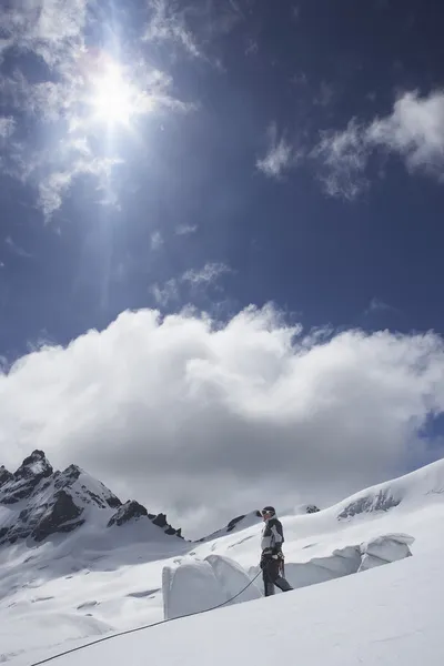 Альпинист на снежном склоне — стоковое фото
