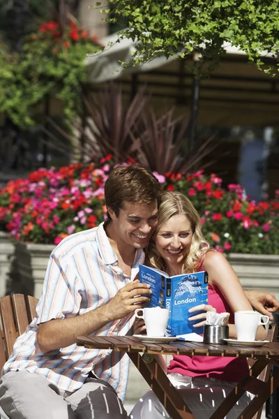 Couple sitting at outdoor cafe laughing — Stock Photo, Image