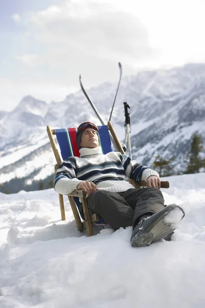 Лыжник отдыхает на шезлонге — стоковое фото