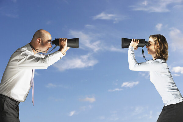 Business colleagues looking through binoculars