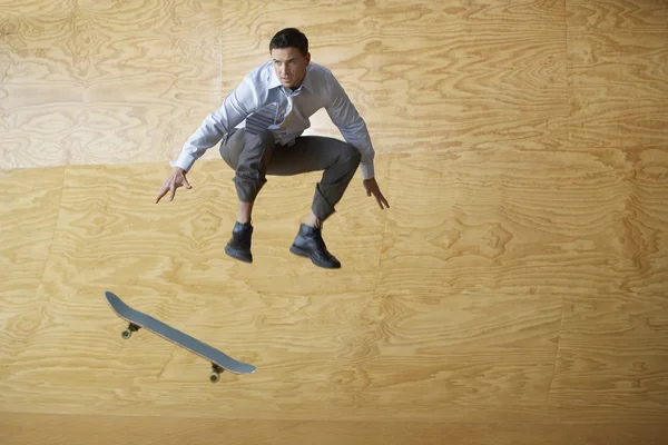 Man crouching springen van skateboard — Stockfoto