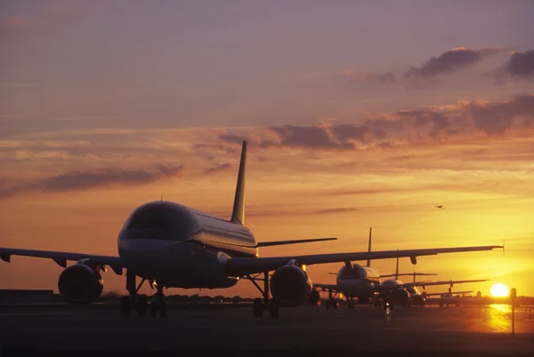 Flygplan sitter på asfalten i solnedgången — Stockfoto