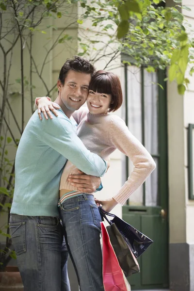 Couple with shopping bags embracing — Stock Photo, Image