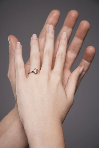 Manos mostrando el anillo de compromiso de la mujer — Foto de Stock