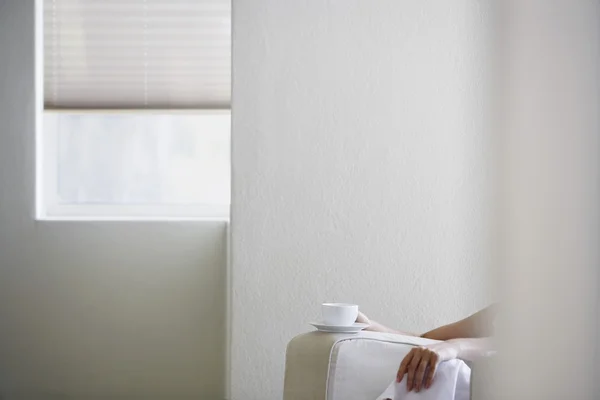 Mujer sentada en sillón con taza — Foto de Stock