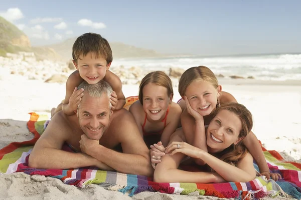 Familie liggend op het strand. — Stockfoto