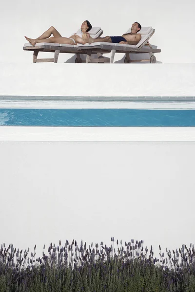 Couple Sunbathing by Pool — Stock Photo, Image