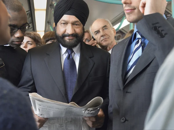 Podnikatel čtení novin ve vlaku — Stock fotografie