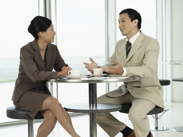 Empresários sentados à mesa conversando — Fotografia de Stock