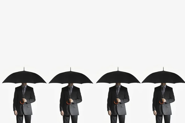 Businessmen holding umbrellas — Stock Photo, Image