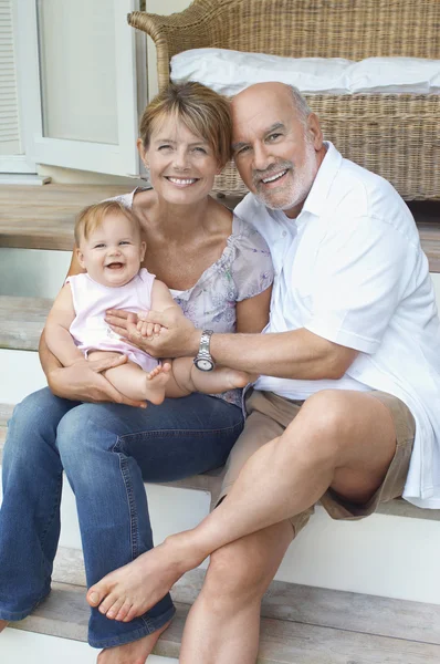 Grandparents sitting with granddaughter — Stock Photo, Image