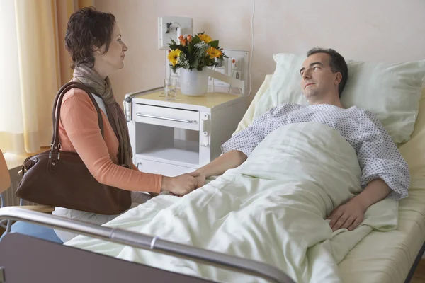 De bezoekende echtgenoot van de vrouw in het ziekenhuis — Stockfoto
