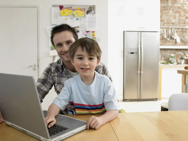 Pai e filho usando laptop — Fotografia de Stock