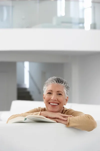 Vrouw met boek op sofa — Stockfoto