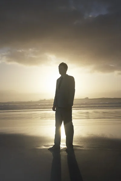 Homme d'affaires debout sur la plage — Photo