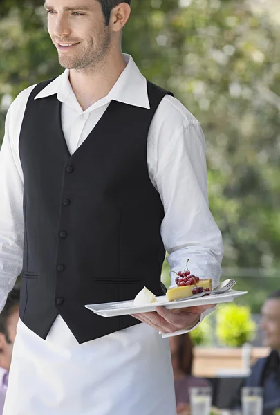 Ober uitvoering stuk van taart in café — Stockfoto