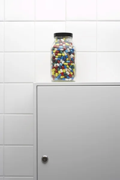 Pot de pilules sur armoire de salle de bains — Photo
