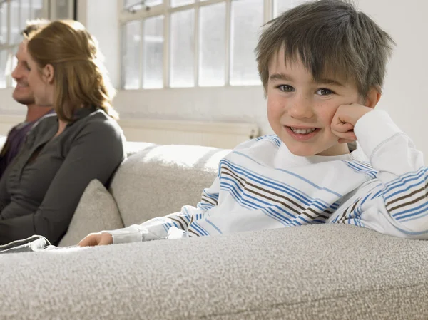 Ragazzo sul divano con i genitori — Foto Stock