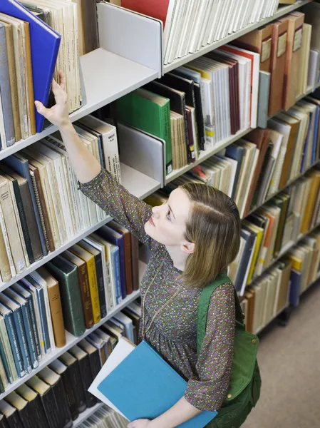 Donna che raggiunge per il libro — Foto Stock