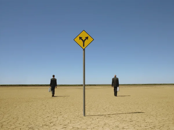 Businessmen with briefcases in desert — Stock Photo, Image