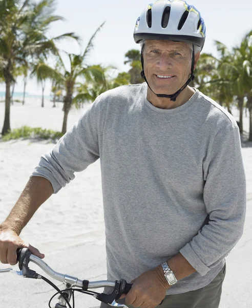 Человек с велосипедом на тропическом пляже — стоковое фото