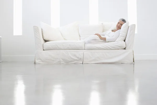 Frau entspannt sich auf Sofa — Stockfoto