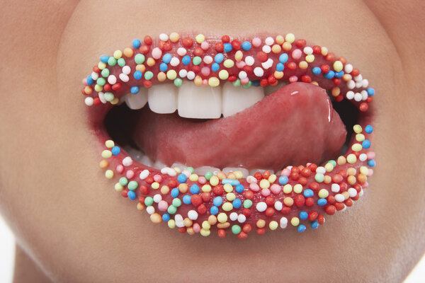 Tongue licking lips covered in sprinkles