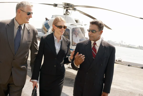 Businesspeople arriving from helicopter — Stock Photo, Image