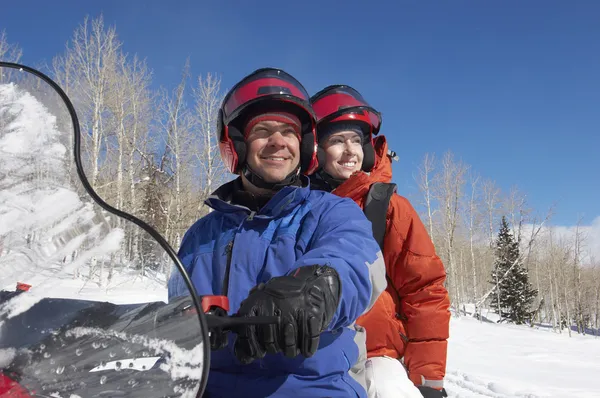 Couple sitting on snowmobile — Stock Photo, Image