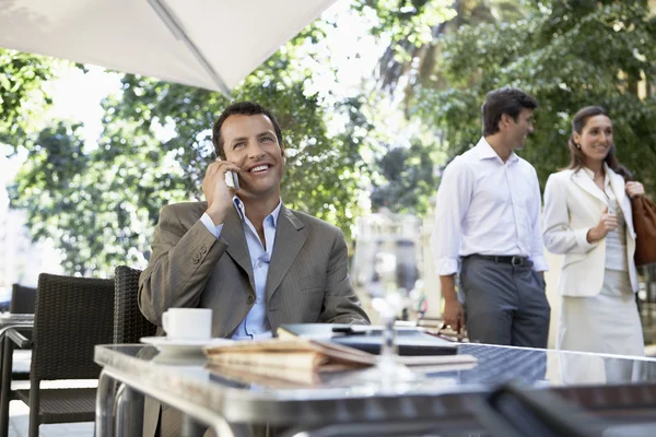 Empresário usando telefone celular no café ao ar livre — Fotografia de Stock