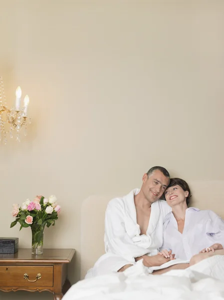 Smiling couple relaxing in bed — Stock Photo, Image