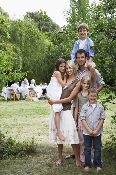 Paar en vier kinderen in tuin — Stockfoto