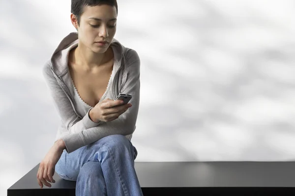 Kvinna på bänk slutar textmeddelande — Stockfoto