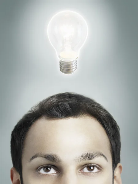 Лампочка над головой человека — стоковое фото