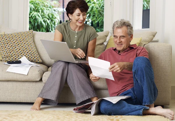 Couple looking at bill and laptop — Stock Photo, Image