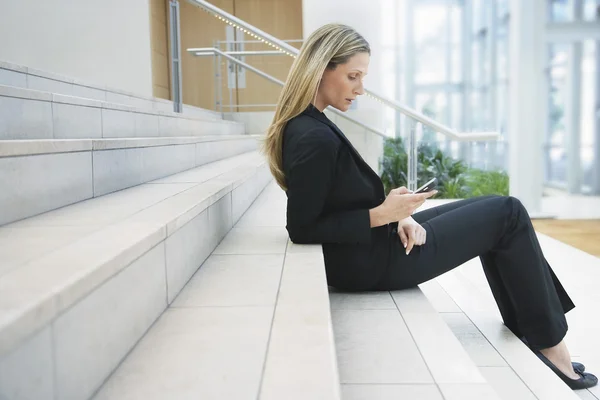 Femme d'affaires regardant le téléphone portable — Photo