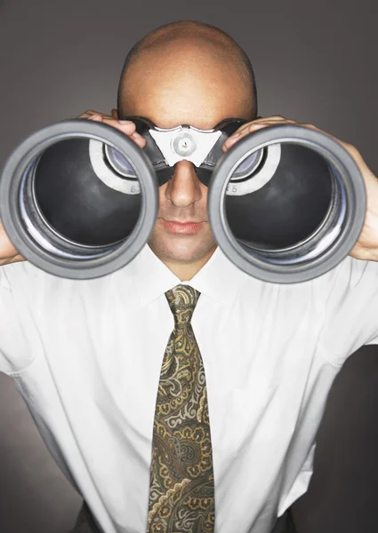 Homem de negócios careca olhando através de binóculos — Fotografia de Stock