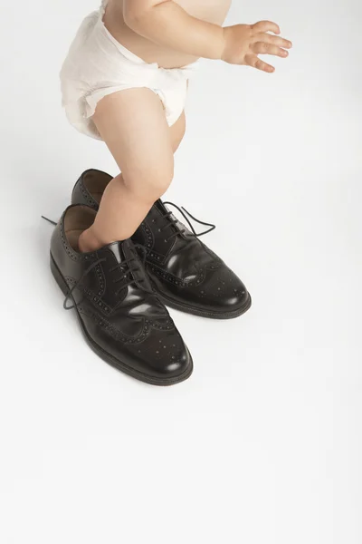 Dziecko stoi w buty męskie — Zdjęcie stockowe